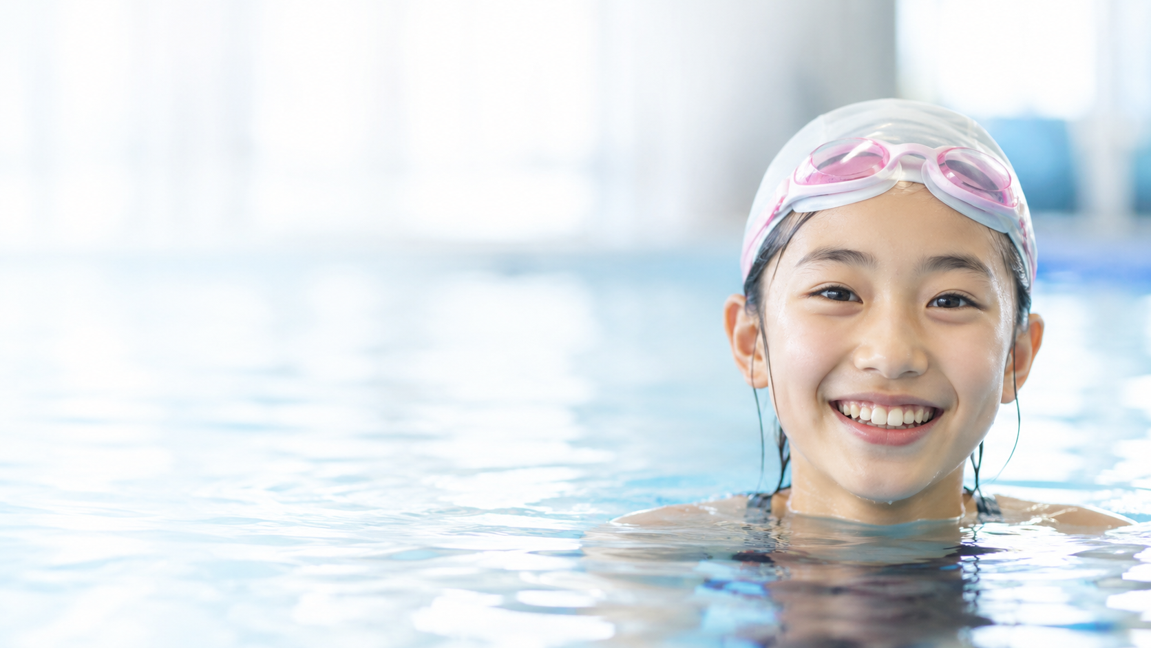 プールで笑顔を見せる小学生女子